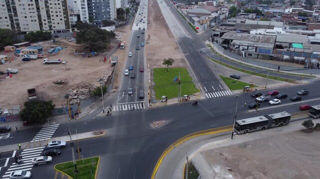 A newly built express way, named "Via Expresa Sur". Drone flies forward while slowly tilting the camera up showing the many buildings in the horizon. Located in Lima, Peru.