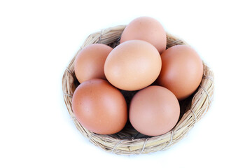 Neat arrangement of chicken eggs in a small basket top View, bright white backdrop, natural texture.