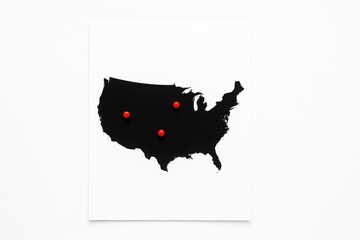 Top view black silhouette United States map on white sheet with three red round markers highlighting regions