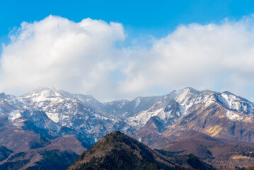 Fototapeta premium Majestic Mount Nyoho Nyoho-san in Nikko, Japan. Breathtaking winter landscape with snowy peaks and a dramatic mountain range under a clear blue sky. Perfect for Asian travel concepts.