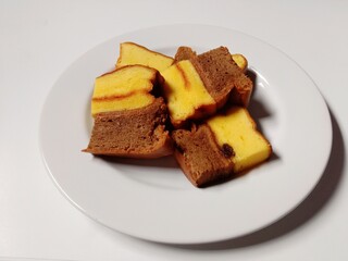 slice of chocolate vanilla marble cake with raisins. close-up of marble cake slices on white plate.