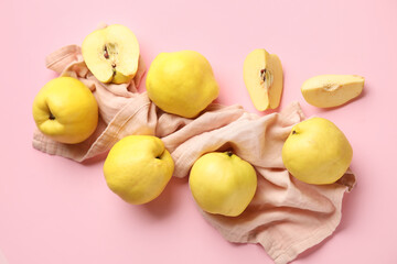 Composition with napkin, fresh quinces with cut pieces on pink background