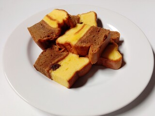 slice of chocolate vanilla marble cake with raisins. close-up of marble cake slices on white plate.