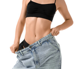 Young woman in loose jeans on white background. Liposuction concept