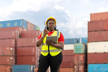 Woman in Hard Hat Using Digital Devices in Industrial Yard, African American Port Supervisor Overseeing Cargo Operations and Inventory Check, Manager Communicating on Walkie-Talkie