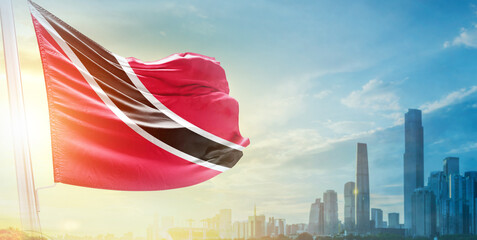 Trinidad and Tobago flag wavering in beautiful clouds with building skyline. The flag with drone...