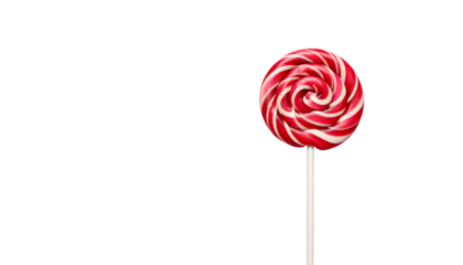 A red and white swirled lollipop on a stick against a stark black background
