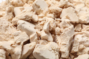 Pieces of fresh yeast as background, closeup