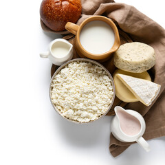 Wooden board with dairy products, bun and napkin on white background