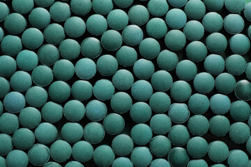 Many spirulina tablets as background, closeup