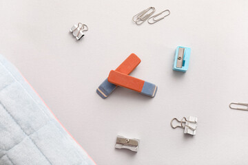 Erasers with sharpeners and paper clips on white background