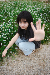 Young Girl Gesturing Stop in Flower Field