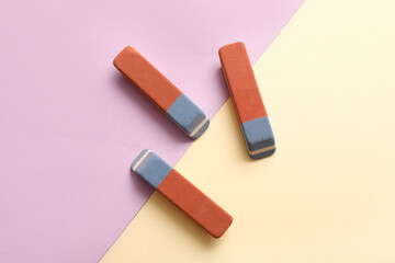 School erasers on color background