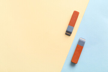 School erasers on color background