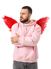 Thoughtful young man with Cupid's wings on white background. Valentine's Day celebration