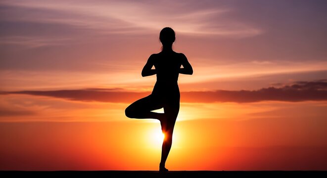 A silhouette of a person practicing a yoga pose, tree pose, against a vibrant sunset sky