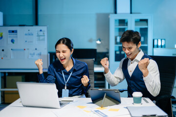 Asian business team celebrating success with high five, showing teamwork, motivation, and positive collaboration in modern corporate office.