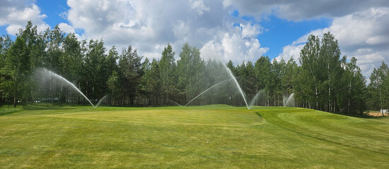 Sprinklers Watering a Golf Course on a Sunny Day