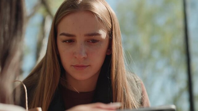 peaceful knitting scene with focused woman outside, tranquil scene of woman carefully stitching in open park setting, relaxed woman attentively working on needlework amidst peaceful park environment
