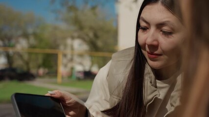 woman guides younger friend outdoors, gentle lady instructs young companion on creative projects outdoors, outdoor setting where nurturing woman kindly mentors young friend in crafting activities