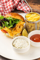 Crispy fried chicken burger served with fries and creamy dips