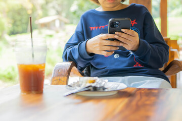 Cropped shot of woman typing a message on a smartphone device, replying to friends on a social network post