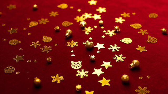 Gold confetti stars and snowflakes scattered across a rich red surface - Powered by Adobe
