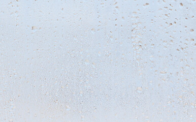 Frozen water drops on glass as an abstract background.