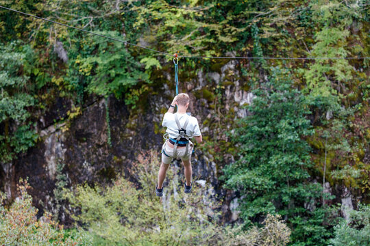 A man is hanging from a zip line