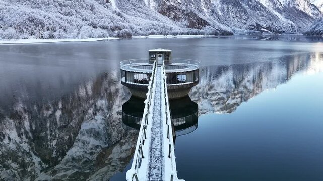 Snow covered platform on Kl&ouml;ntalersee with winter alpine reflections Switzerland