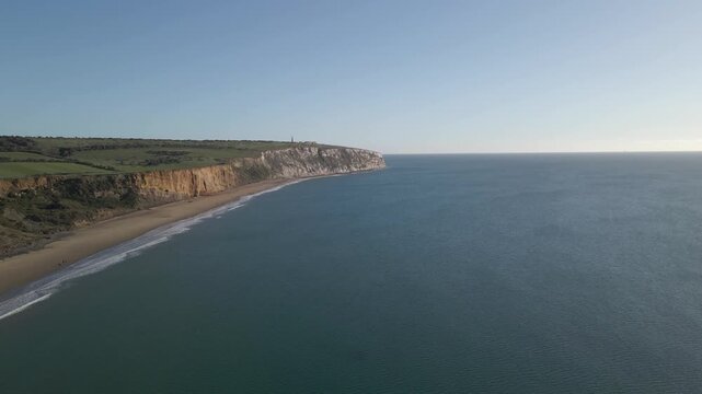 Aerial view of Sandown a seaside resort and civil parish on the south-east coast of the Isle of Wight, England. Drone rotating to the left over the sea showing the white cliffs and beach. 4K