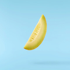 Fresh ripe Galia Melon falling in the air isolated on blue background