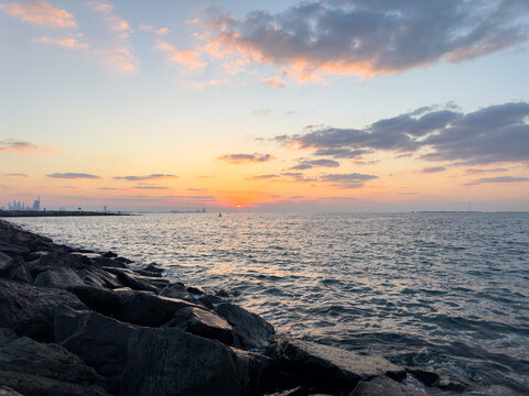 Beautiful sunset over rocky coastline and ocean in Dubai, UAE