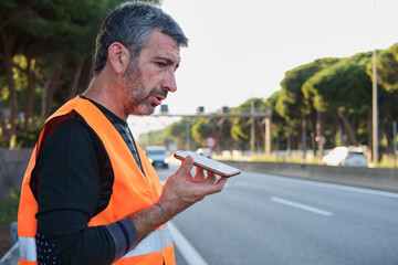 Man calling roadside assistance for car breakdown on highway