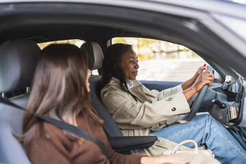 Two women sharing a conversation while driving a car. Enjoying carpooling, friendship, and travel...