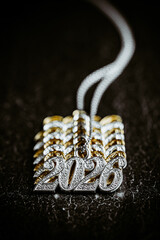 Several necklace pendants made of gold and silver with glittering zirconia, strung on a silver chain, numbers 2026 for the New Year's Eve celebration