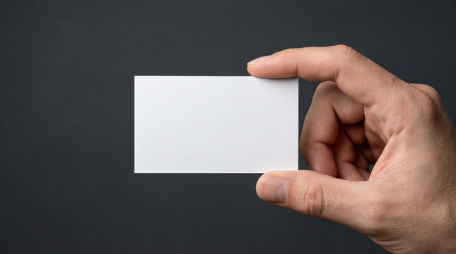 Hand holding blank business card against dark background, showcasing potential for branding and personal identity in professional settings