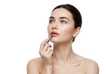 Young caucasian woman (20s) with dark hair, bare shoulders, applying red lip balm to lower lip, thoughtful gaze, high-key beauty light, blurred white studio background, concept of elegant self-care