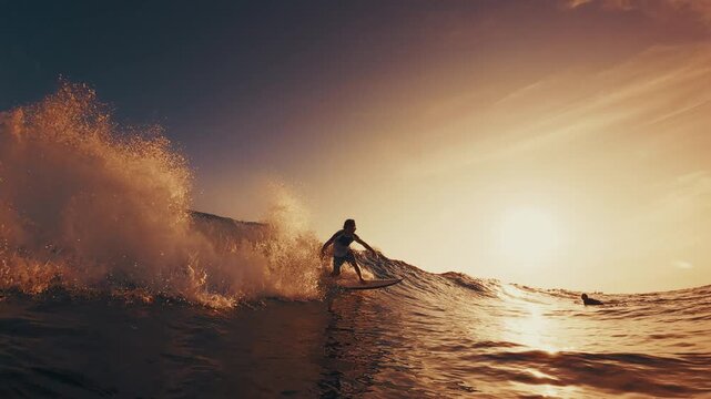 Surfer rides the ocean wave in the Maldives. In water and underwater view of the surfer on the wave