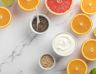 Healthy breakfast ingredients oranges, grapefruit, yogurt, chia seeds, and marble background