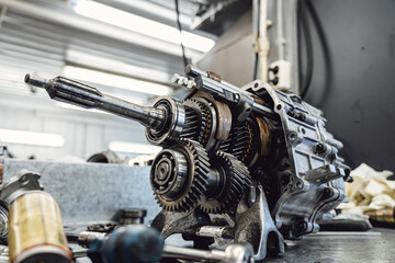 Closeup of transmission details: gears, shafts, and bearings on a grimy workbench. Technical shot ideal for engineering and industrial diagnostics documentation.