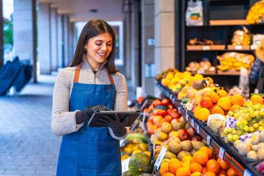 Happy woman using tablet checking inventory at fruit stand