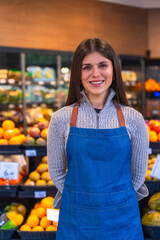 Female supermarket employee smiling working in grocery store