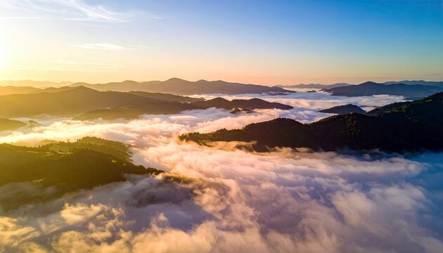 Aerial view of a mountain range with clouds at sunrise, bathed in golden light. The image captures the natural beauty of the landscape. - Powered by Adobe