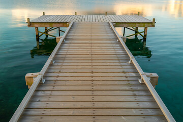 Wooden Pier Extending into Calm Water at Sunset dock