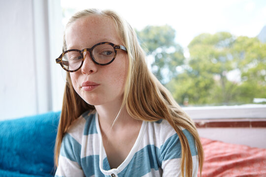 Girl, thinking and side eye with glasses in home for questionable thought, idea or guess. Geeky child, teenager or nerd in wonder with spectacles or thoughtful expression for contemplation in house