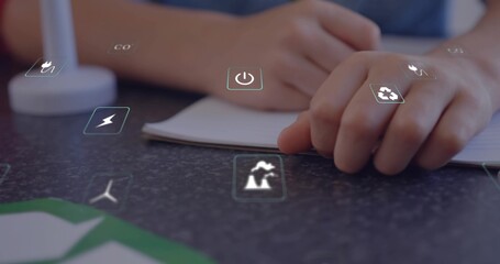 Writing children's hands tracing notes at study desk, open notebook and holographic energy icons