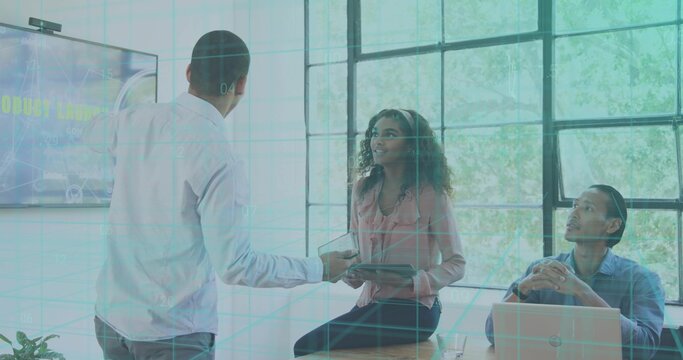 Handing tablet, man offering to woman in pink blouse on table in conference room, with laptop