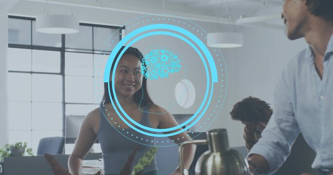 Smiling Asian woman in sleeveless top standing in modern office with blue HUD graphic and kettle