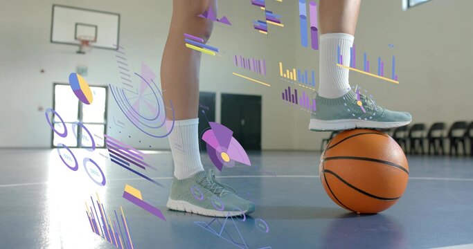 Balancing female athlete's legs resting on basketball in gym, wearing sneakers, socks, AR graphics - Powered by Adobe